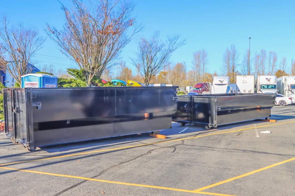 Professional dumpster rental service with roll-off container on residential driveway in Fowler